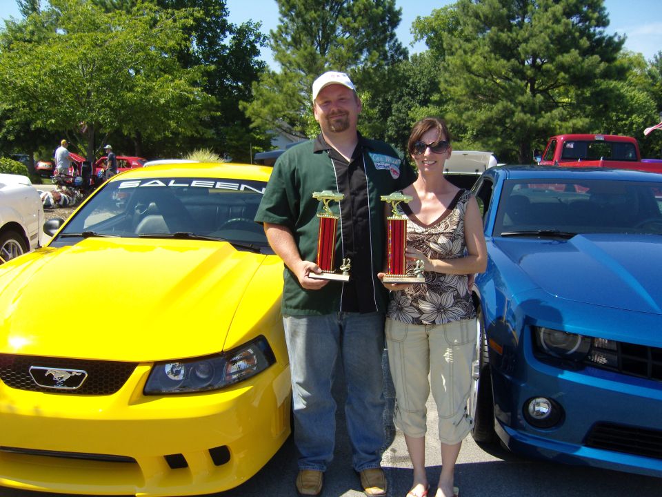 Yellow Saleen Mustang with a black grille and a Ford emblem, seen from the front-left
