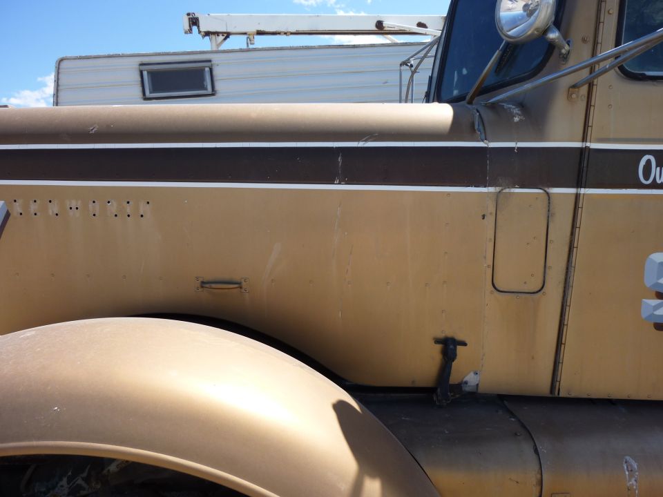 Tan truck fender and side door with brown and white stripe. "KENWORTH" text visible