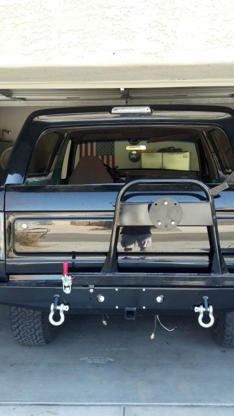 1995 Ford Bronco - Rear view of a black 1995 Ford Bronco, equipped with a spare tire carrier and tow hitch.