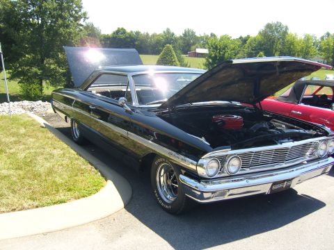 2007 Ford Mustang - 1963 Ford Galaxie 500 on display, engine compartment visible under the open hood.