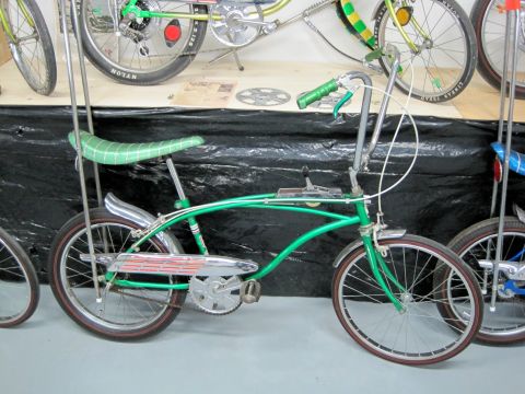 1953 Ford Mainline - A green bicycle with a tall sissy bar and a checkered seat is displayed alongside other bicycles.