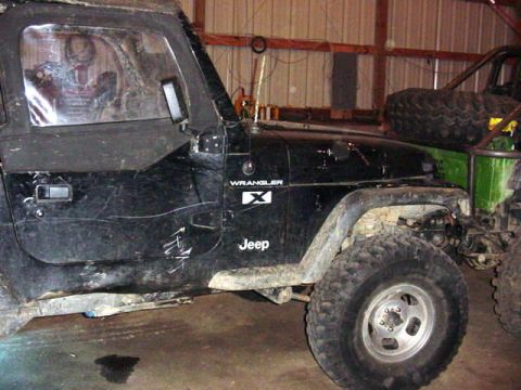 1992 Ford Bronco - Side view of a black Jeep Wrangler TJ, with another Jeep visible behind it.