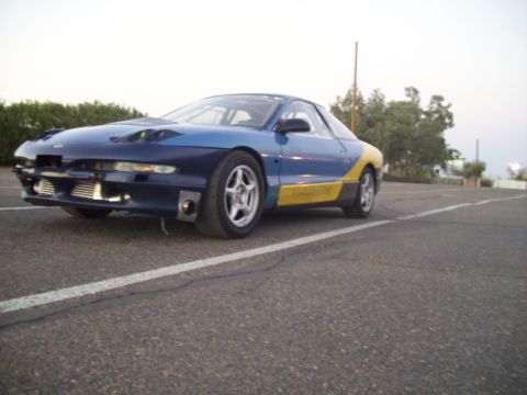 1995 Ford Probe - This modified sports car features a two-tone blue and yellow paint scheme with an exposed front-mounted intercooler.
