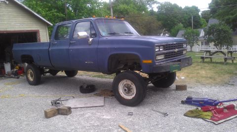 1991 Chevrolet Cheyenne - Blue 1991 Chevrolet Cheyenne crew cab pickup truck is parked outside a garage with tools nearby.
