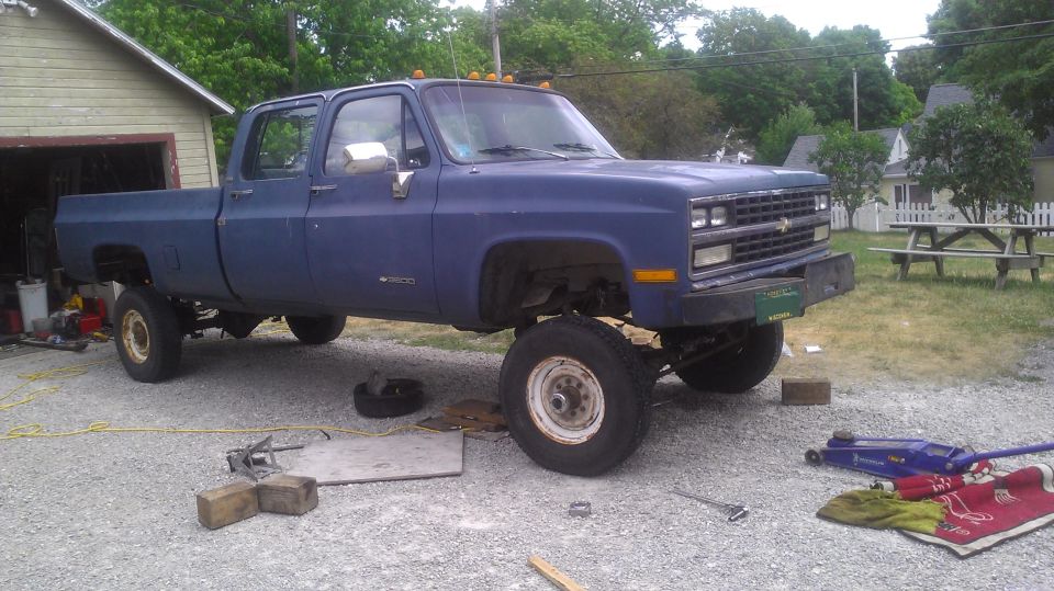 1991 Chevrolet Cheyenne crew cab pickup truck parked outside a garage