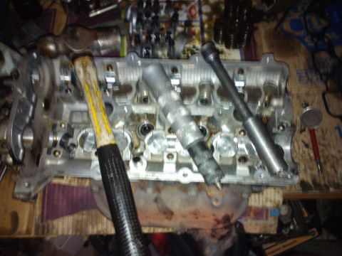 1995 Ford Probe - Engine cylinder head disassembled with tools laid out, suggesting repair or maintenance work.