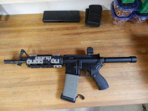 1996 Ford Bronco - An AR-15 style rifle is displayed with ammunition magazines and containers of bullets on a wooden table.