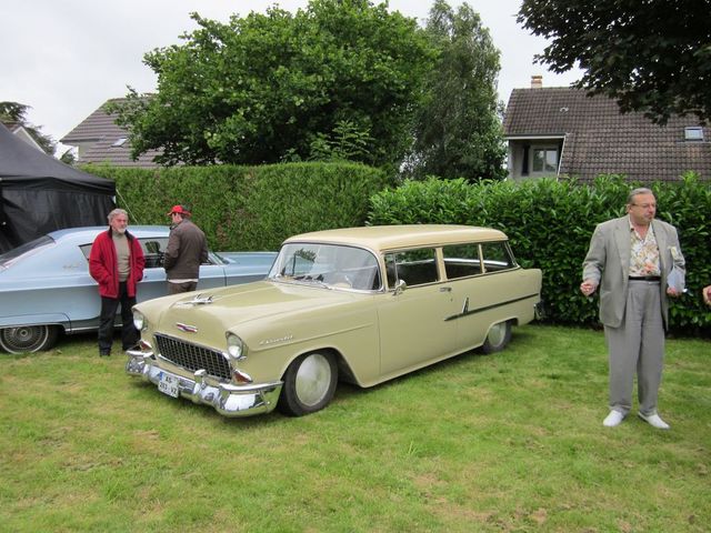 1955 Chevrolet Nomad station wagon parked on grass next to a light blue sedan