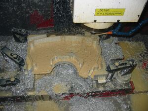 1993 Ford Taurus - Machining a metal component on a CNC machine, metal shavings cover the work area.