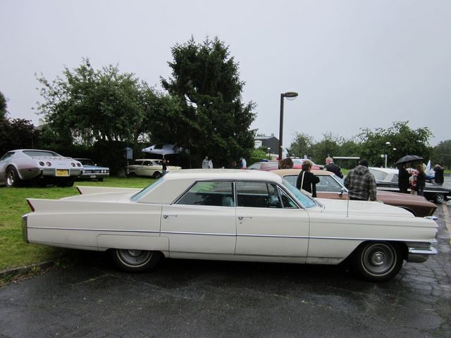1963 Cadillac Sedan de Ville parked next to other cars at an outdoor event