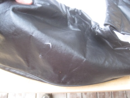 1993 Ford Bronco - Black vinyl seat cover, likely for a 1993 Ford Bronco, shows some wear and tear.