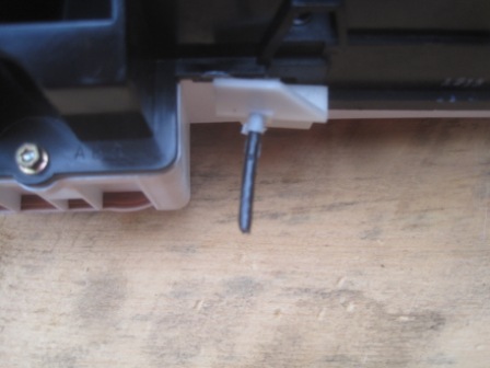 1993 Ford Bronco - Detail of a plastic clip and metal pin mechanism, likely from a vehicle interior component.