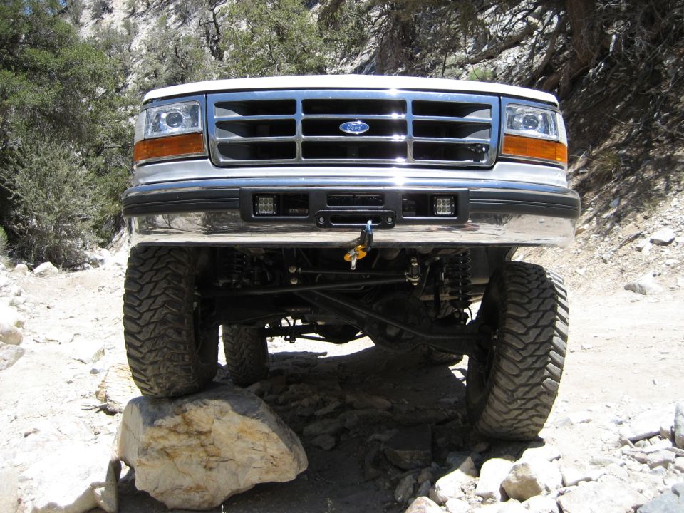 1996 Ford Bronco front grille and bumper with aftermarket lights, tires on rocks