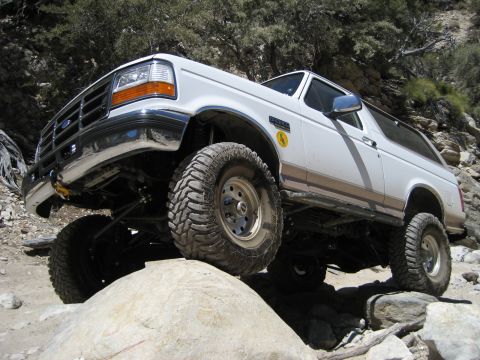 1996 Ford Bronco - White 1996 Ford Bronco navigating rocky terrain off-road.