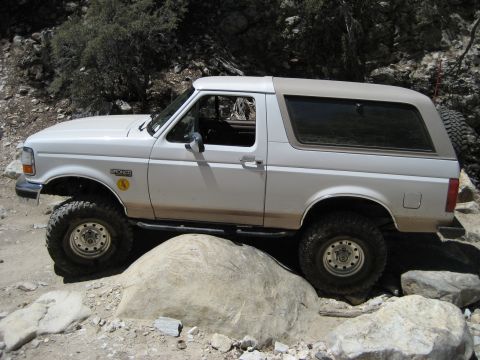 1996 Ford Bronco - White 1996 Ford Bronco navigating a challenging rocky terrain.
