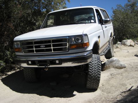 1996 Ford Bronco - White 1996 Ford Bronco navigating a rocky off-road path.