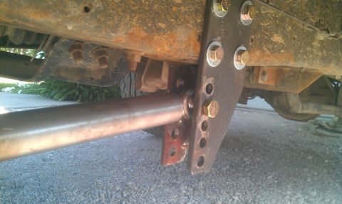 1987 Ford Bronco - This image shows a close-up view of a modified suspension component attached to the frame of a vehicle.