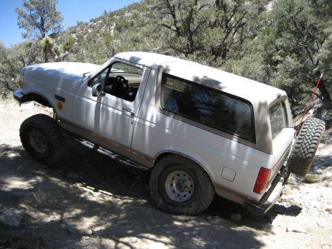 1996 Ford Bronco - This lifted 1996 Ford Bronco navigates a challenging off-road terrain with its spare tire mounted on the rear.