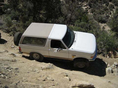 1996 Ford Bronco - This 1996 Ford Bronco is navigating a challenging off-road path with steep inclines and loose rocks.