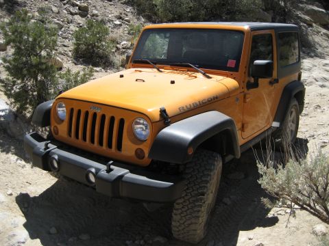 1996 Ford Bronco - This orange Jeep Wrangler Rubicon is shown off-road on a rocky trail.