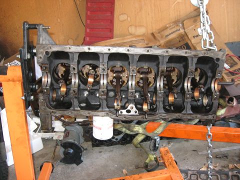 1981 Ford Bronco - The internal components of an engine block are visible while it's supported by an engine stand.