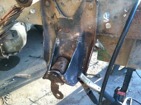 1983 Chevrolet C/K Pickup - A rusty metal bracket with a roller is clamped in place, possibly for repair or modification.