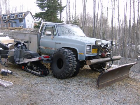 1983 Chevrolet C/K Pickup - Modified pickup truck equipped for winter conditions with a snowmobile and plow attachment.