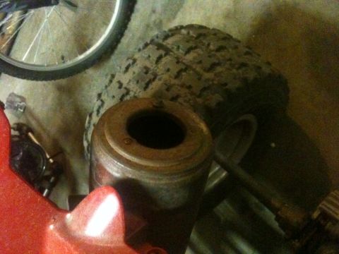 1990 Chevrolet Suburban - A close-up view of a rusty metal component, with a tire and bicycle wheel visible in the background.