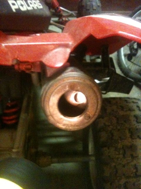1990 Chevrolet Suburban - Exhaust pipe detail on a red Polaris ATV, showing wear and rust.