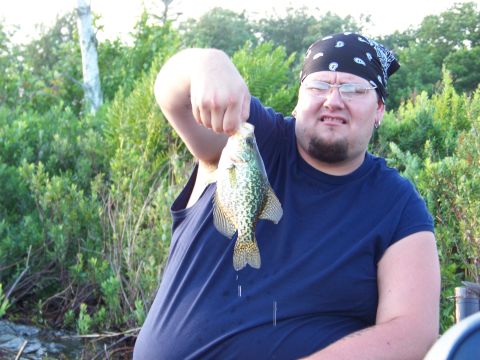 1996 Ford F-150 - A man proudly displays a freshly caught crappie fish while outdoors.
