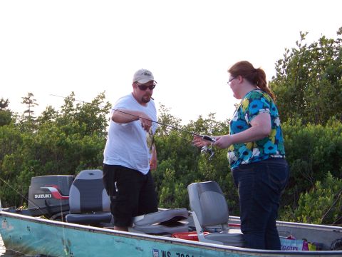1996 Ford F-150 - A man and woman are fishing from a boat on the water.