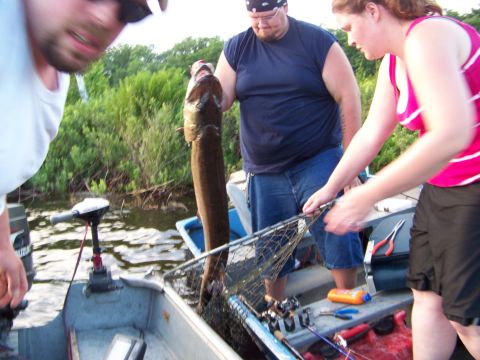1996 Ford F-150 - A group of people are on a boat, proudly displaying a large fish they have caught.