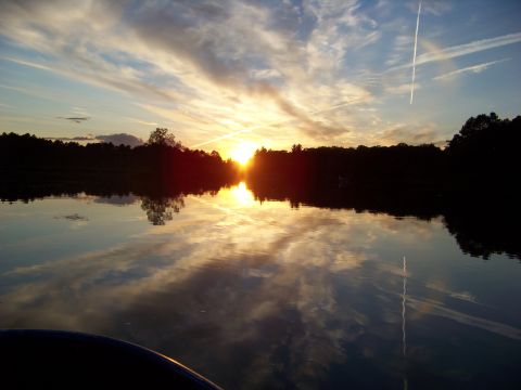 1996 Ford F-150 - The sun sets over a calm lake, casting colorful reflections on the water's surface.
