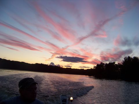 1996 Ford F-150 - A person is on a boat during a sunset with colorful clouds in the sky.