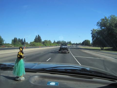 1989 Ford Bronco - A truck is being towed on a sunny day on the highway.