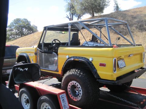 1989 Ford Bronco - This yellow 1989 Ford Bronco is equipped with a roll cage and is being transported on a trailer.