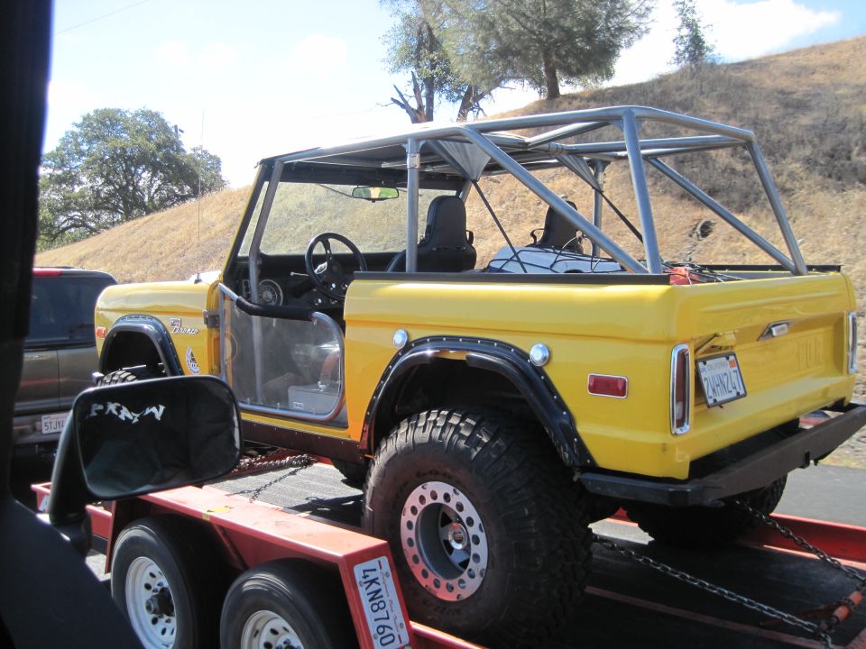 Yellow 1989 Ford Bronco with roll cage on a trailer