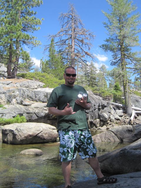 1989 Ford Bronco - A man poses for a photo outdoors near a body of water with trees and rocks in the background.