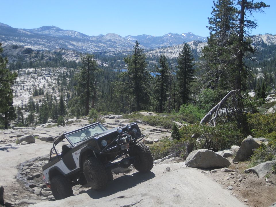 Black and white off-road vehicle with large tires on a rocky trail