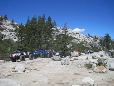 1989 Ford Bronco - A group of off-road vehicles navigates a challenging rocky path in a scenic, mountainous area.