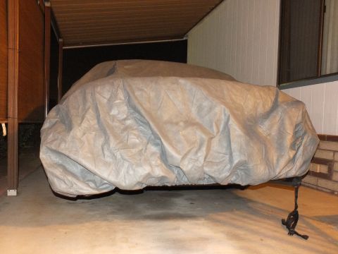 2003 Ford Crown Victoria - Side view of a vehicle in a fitted gray cover, tie-down strap hanging below.
