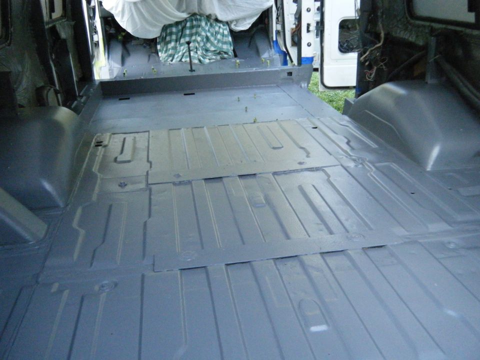 Interior of a 1988 Ford E350 van cargo area, showing the floor panels and wheel wells