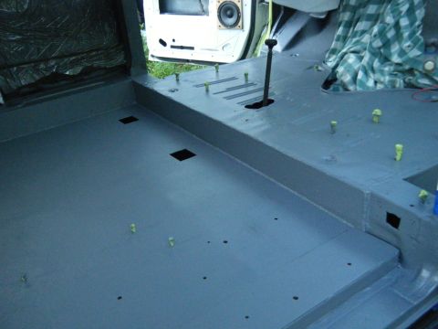 1988 Ford E350 - The interior of a van shows a gray floor, gear shifter, and an open door with a speaker visible.