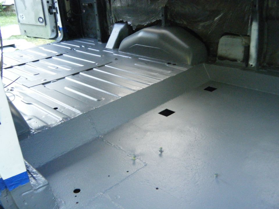 Gray painted interior cargo area of a van with metal floor panels