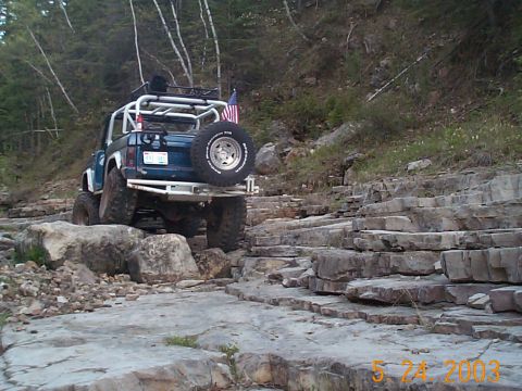 1977 Ford Bronco - This modified SUV navigates a challenging rocky path, its off-road capabilities.