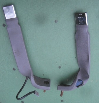 1993 Ford Bronco - Two seatbelt buckles are shown, one with a wire harness, against a light green background.