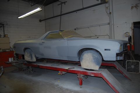 1975 Ford Ranchero - A 1975 Ford Ranchero is shown on a lift in a garage, ready for paint.