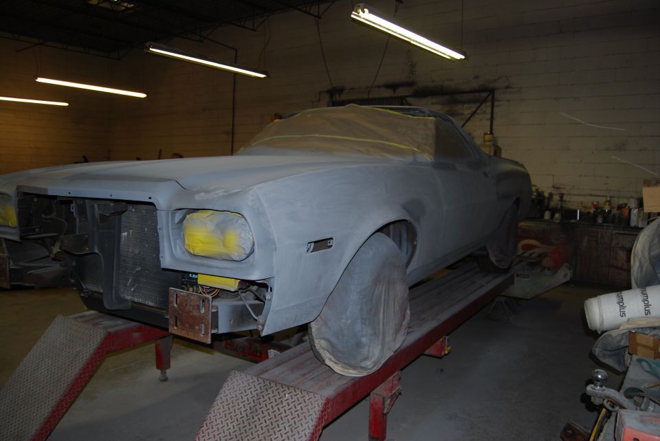 1975 Ford Ranchero bodywork in progress, covered in primer and on a lift