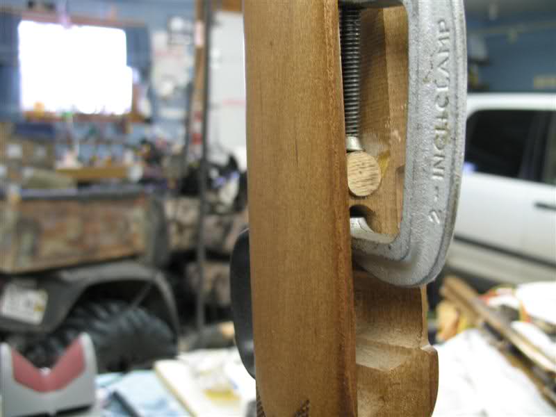 Close-up of a 2-inch clamp holding two pieces of wood together in a workshop