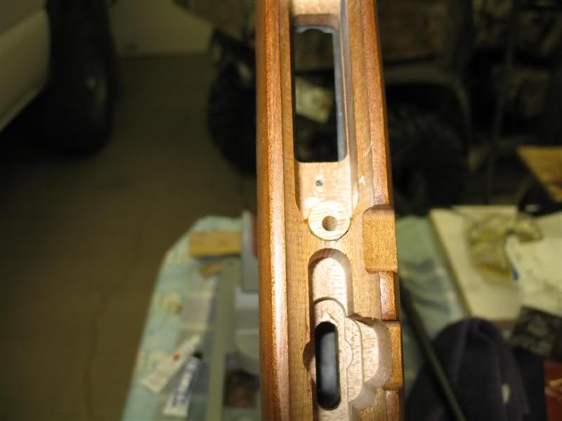 Close-up of a wooden rifle stock with internal mechanisms visible